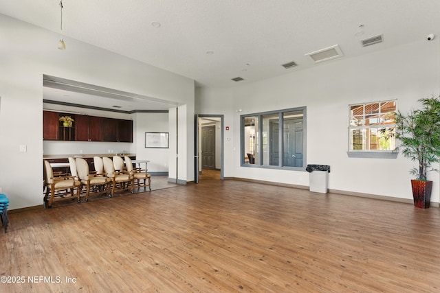 living room with light wood finished floors, baseboards, and visible vents