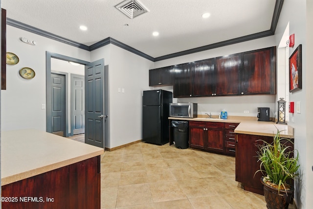 kitchen with visible vents, ornamental molding, light countertops, freestanding refrigerator, and stainless steel microwave