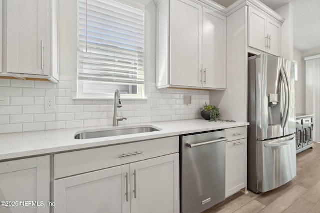 83 Woodgate Dr, Ponte Vedra, FL 32081 - kitchen featuring light wood-style floors, tasteful backsplash, white cabinetry, appliances with stainless steel finishes, and a sink