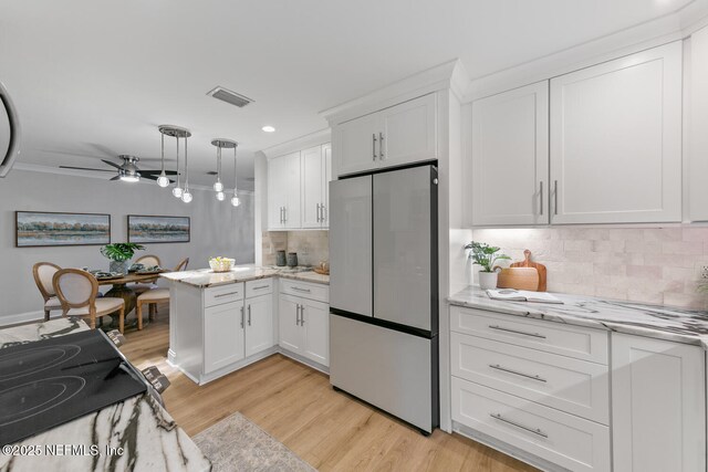 1018 14th Ave N, Jacksonville Beach, FL 32250 - kitchen featuring recessed lighting, freestanding refrigerator, backsplash, white cabinets, and visible vents