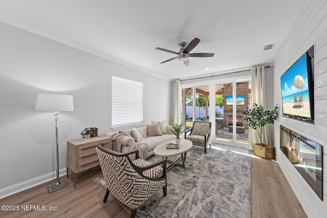 1018 14th Ave N, Jacksonville Beach, FL 32250 - living room with ceiling fan, ornamental molding, a large fireplace, visible vents, and wood finished floors