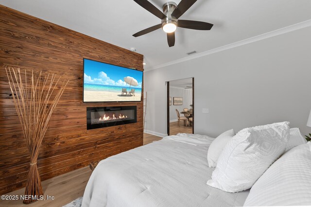 1018 14th Ave N, Jacksonville Beach, FL 32250 - bedroom with a glass covered fireplace, ornamental molding, visible vents, ceiling fan, and wood finished floors