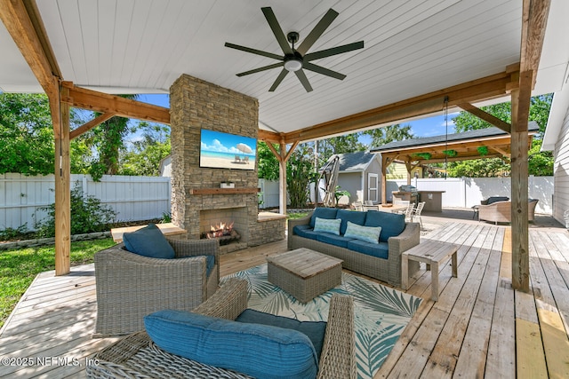 1018 14th Ave N, Jacksonville Beach, FL 32250 - view of patio featuring a wooden deck, an outdoor living space with a fireplace, a fenced backyard, a ceiling fan, and a storage unit