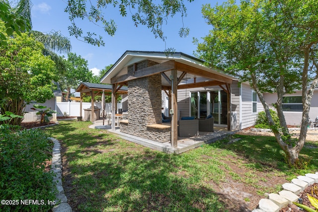1018 14th Ave N, Jacksonville Beach, FL 32250 - back of property featuring a yard, a patio area, a gazebo, stone siding, and fence