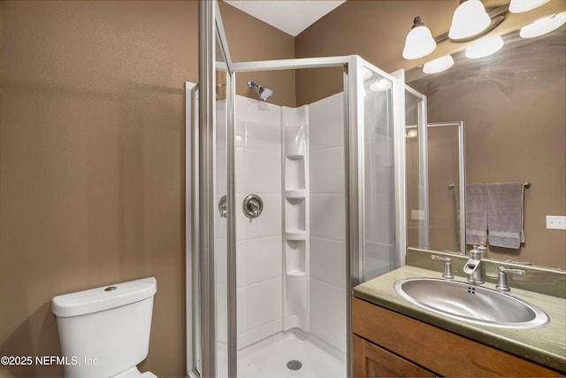 full bath with a shower stall, vanity, and toilet