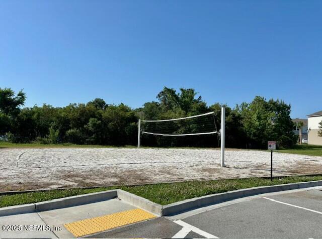view of property's community featuring volleyball court and uncovered parking