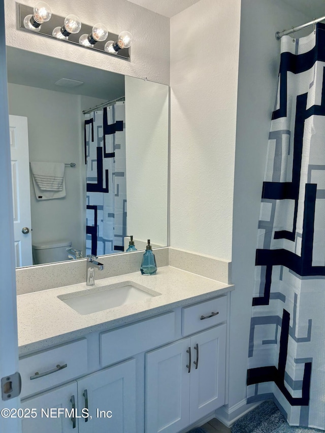 full bathroom with a shower with curtain, vanity, and toilet