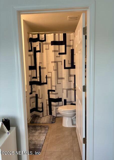bathroom featuring toilet, tile patterned floors, and visible vents