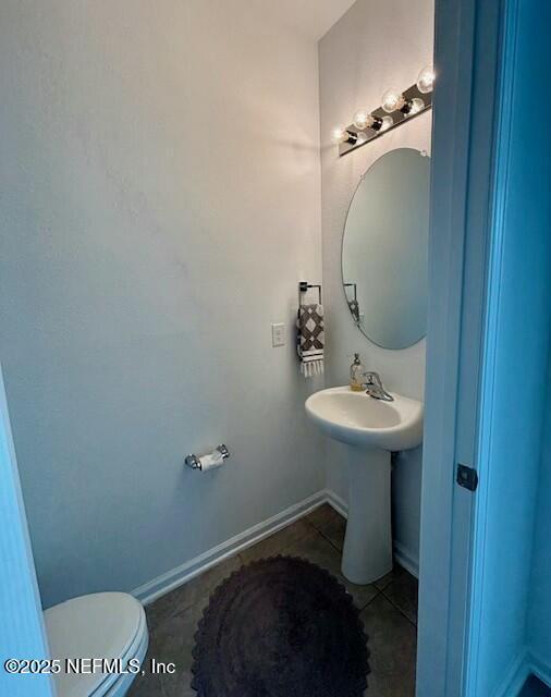 half bathroom with tile patterned floors and toilet