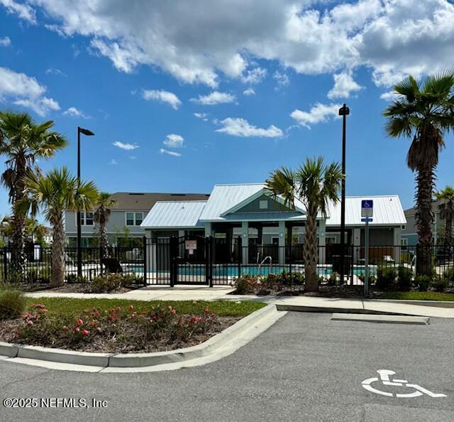 view of property with a community pool and fence