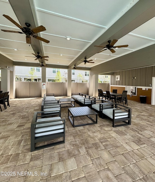view of patio featuring an outdoor hangout area, a ceiling fan, outdoor dining area, and fence