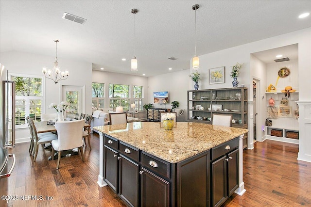 225 Garden Wood Dr, Ponte Vedra, FL 32081 - kitchen with pendant lighting, light stone counters, dark wood finished floors, and visible vents