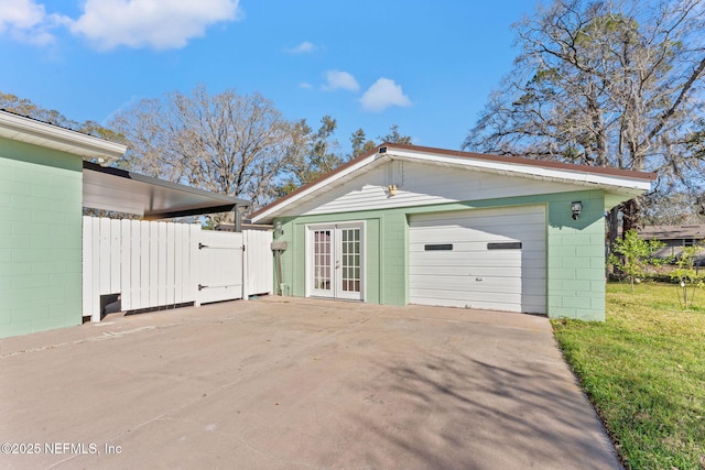 8871 Manson Cir, Jacksonville, FL 32220 - detached garage featuring concrete driveway, french doors, fence, and a gate