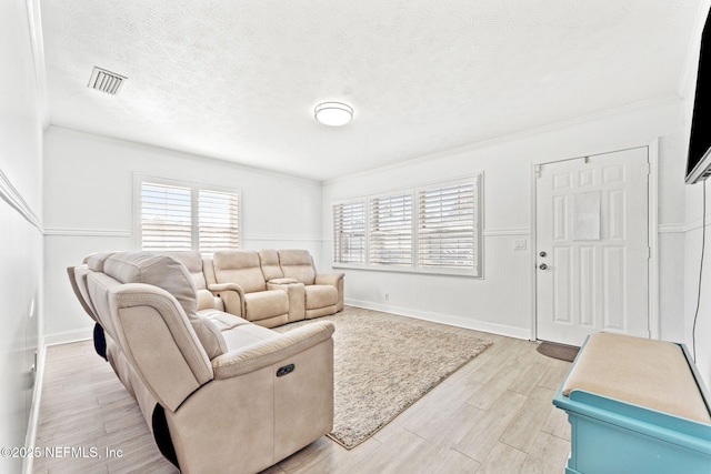 8871 Manson Cir, Jacksonville, FL 32220 - living room featuring a textured ceiling, baseboards, visible vents, and light wood-type flooring