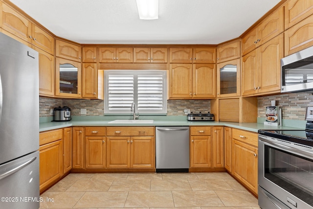 8871 Manson Cir, Jacksonville, FL 32220 - kitchen featuring light countertops, appliances with stainless steel finishes, decorative backsplash, and a sink