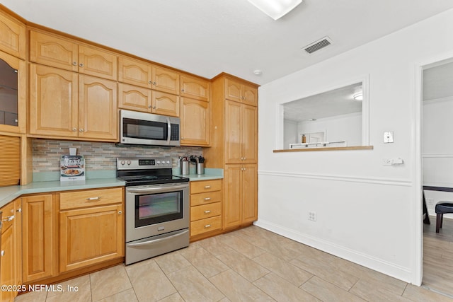 8871 Manson Cir, Jacksonville, FL 32220 - kitchen featuring stainless steel appliances, visible vents, light countertops, and backsplash