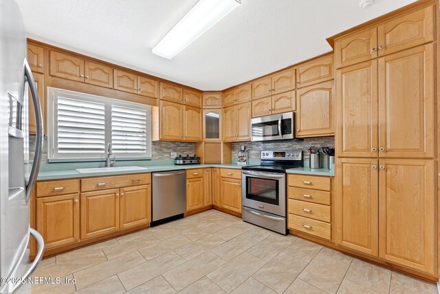 8871 Manson Cir, Jacksonville, FL 32220 - kitchen with a sink, light countertops, appliances with stainless steel finishes, and decorative backsplash