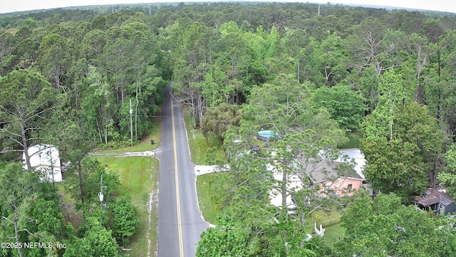 birds eye view of property featuring a view of trees