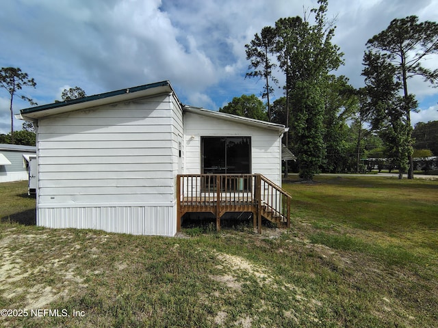 view of property exterior featuring a yard and a deck