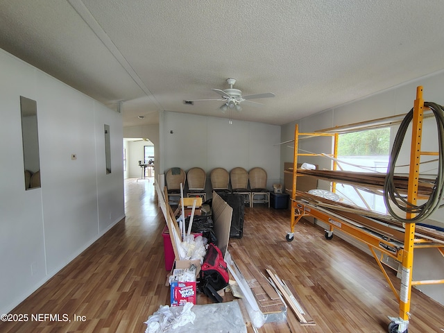 interior space with a textured ceiling, wood finished floors, and arched walkways