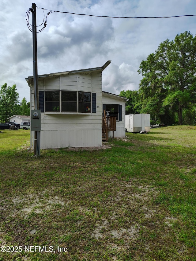 exterior space with entry steps and a front lawn
