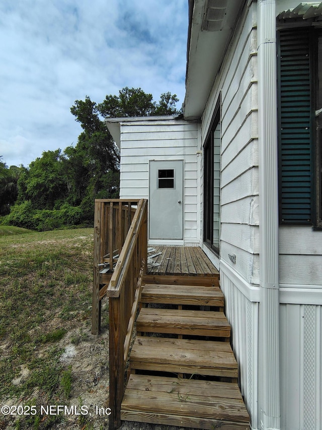 view of exterior entry featuring a wooden deck