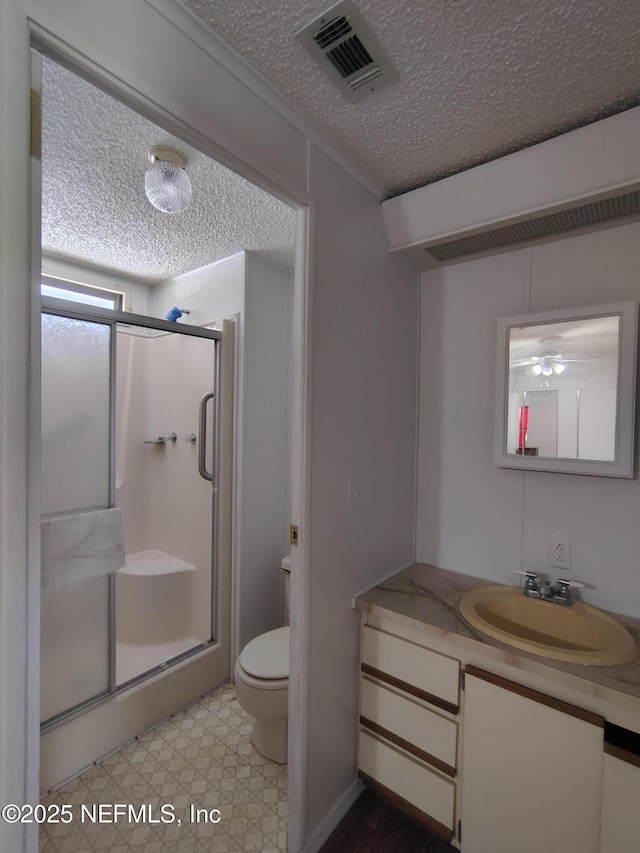 217 Pineway W Ave, Satsuma, FL 32189 - full bath featuring a textured ceiling, a shower stall, toilet, tile patterned floors, and vanity