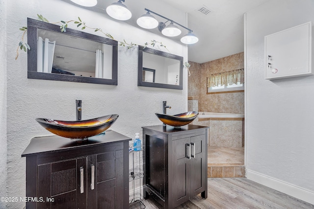 9 Blare Dr, Palm Coast, FL 32137 - bathroom featuring a sink, visible vents, two vanities, and wood finished floors