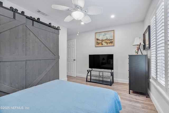 9 Blare Dr, Palm Coast, FL 32137 - bedroom featuring visible vents, baseboards, a barn door, and wood finished floors
