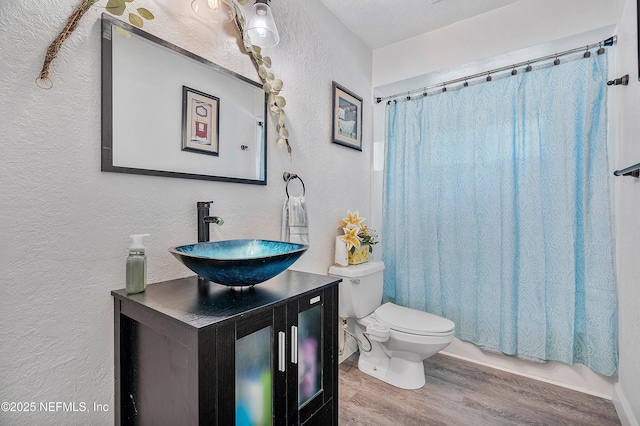 9 Blare Dr, Palm Coast, FL 32137 - bathroom with vanity, a textured wall, toilet, shower / bathtub combination with curtain, and wood finished floors