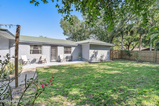 9 Blare Dr, Palm Coast, FL 32137 - rear view of house with metal roof, stucco siding, fence, and a patio area