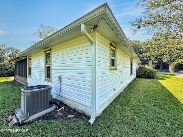 view of property exterior with a lawn and central air condition unit