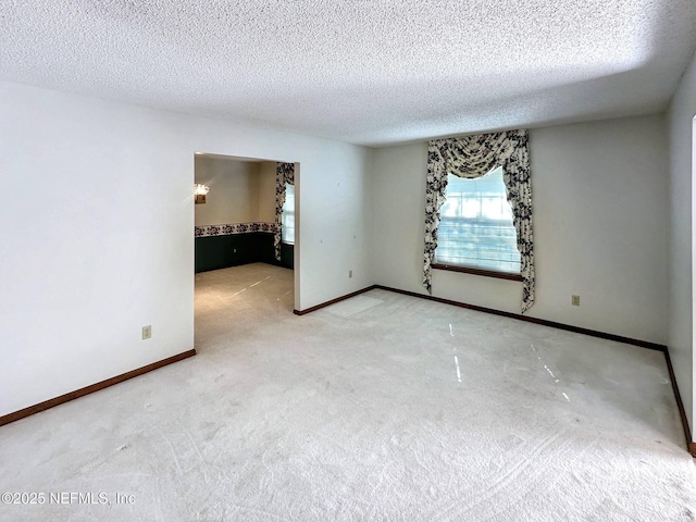 spare room with baseboards, a textured ceiling, and carpet flooring
