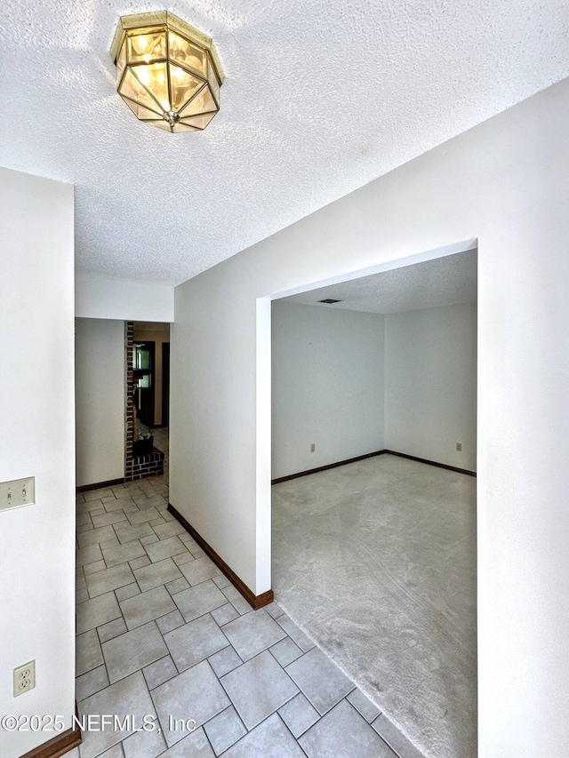 empty room featuring baseboards and a textured ceiling