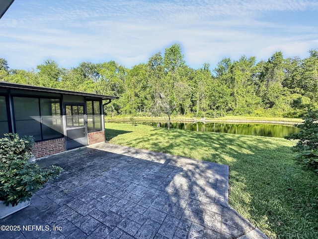 view of patio with a sunroom and a water view