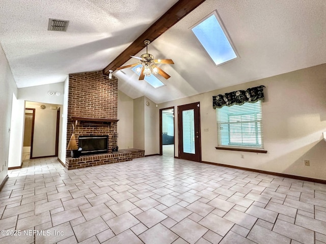 unfurnished living room featuring ceiling fan, a fireplace, visible vents, a textured ceiling, and lofted ceiling with skylight