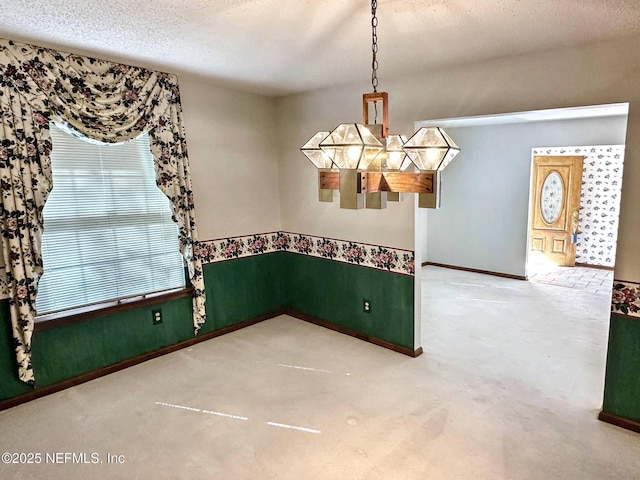 spare room featuring baseboards, a textured ceiling, and carpet