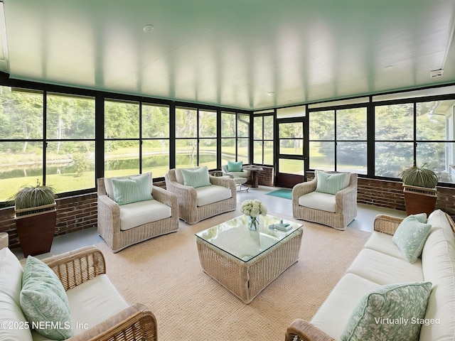 sunroom featuring outdoor lounge area and brick wall