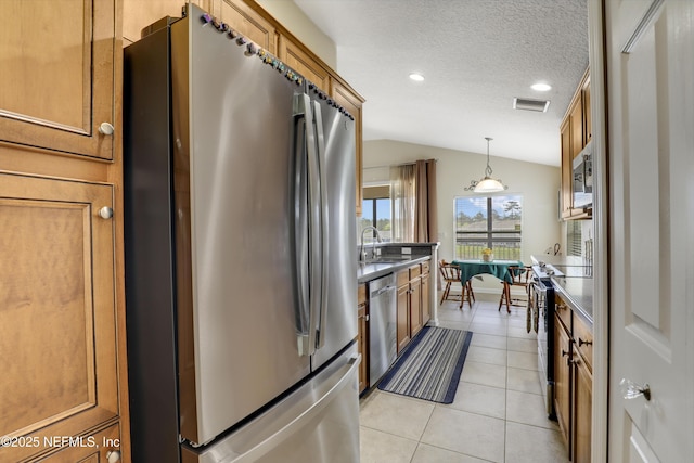 11929 Surfbird Cir Unit 12F, Jacksonville, FL 32256 - kitchen featuring lofted ceiling, brown cabinetry, and appliances with stainless steel finishes