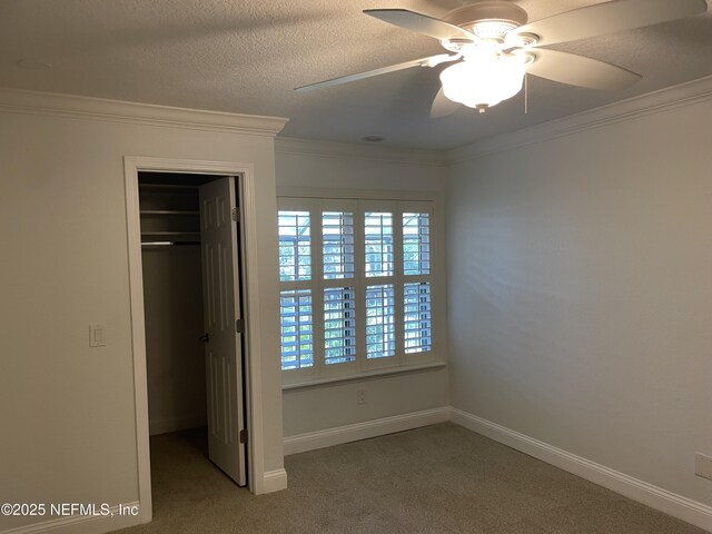 929 Seashell Ln, Ponte Vedra Beach, FL 32082 - unfurnished bedroom with carpet flooring, a textured ceiling, ornamental molding, a closet, and a walk in closet