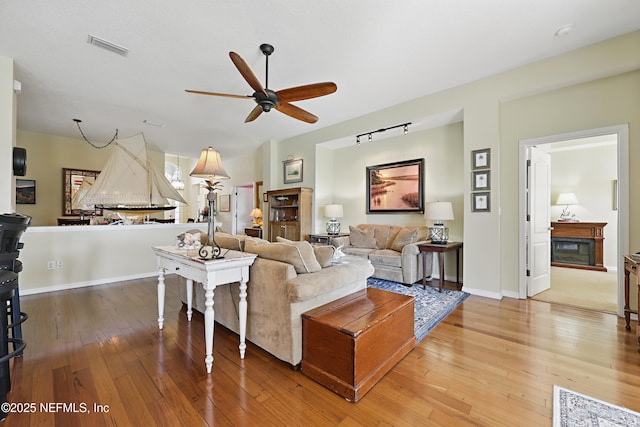 708 El Vergel Ln, Saint Augustine, FL 32080 - living area featuring visible vents, baseboards, a ceiling fan, a fireplace, and wood-type flooring