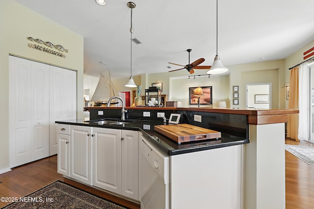 708 El Vergel Ln, Saint Augustine, FL 32080 - kitchen with dark wood-style floors, dark countertops, a kitchen island with sink, white dishwasher, and a sink