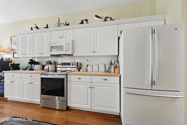 708 El Vergel Ln, Saint Augustine, FL 32080 - kitchen featuring decorative backsplash, white cabinetry, white appliances, and light wood finished floors