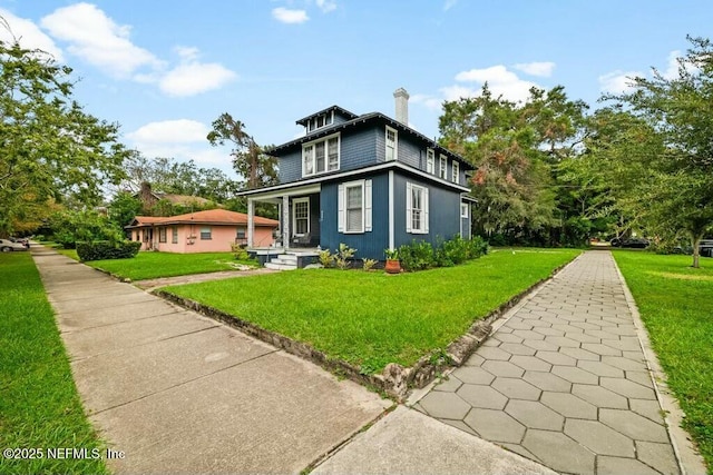 view of front of house featuring a front yard and a chimney