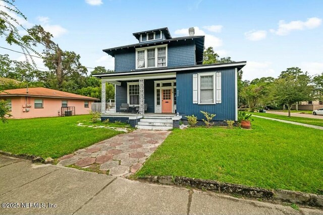 american foursquare style home featuring covered porch and a front lawn