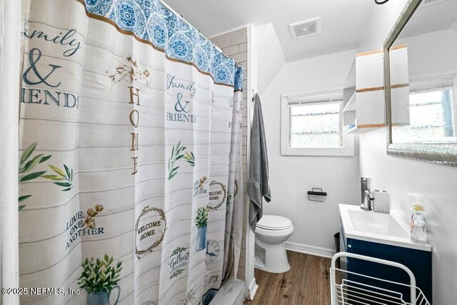 full bath featuring vanity, visible vents, toilet, wood finished floors, and baseboards