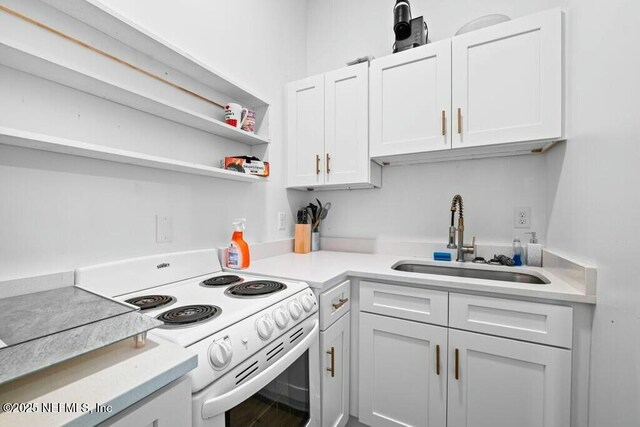 kitchen featuring white electric range oven, light countertops, open shelves, and a sink