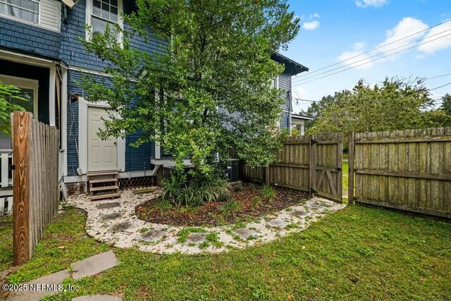 view of yard with entry steps, fence, and a gate