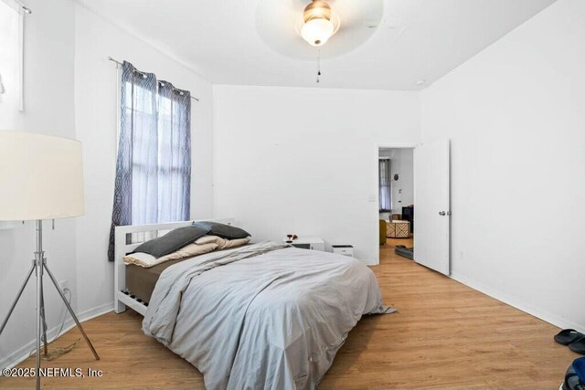 bedroom featuring ceiling fan, baseboards, and wood finished floors