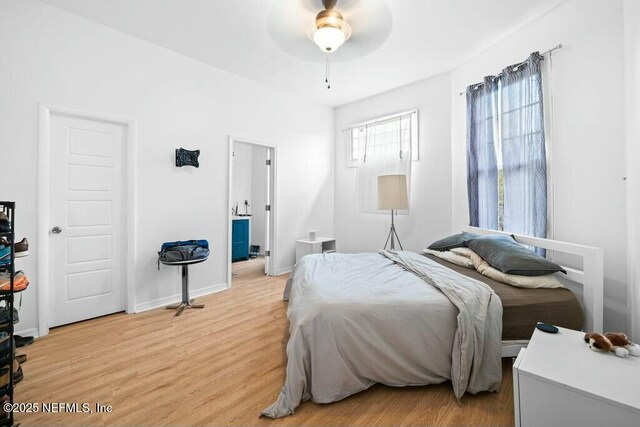 bedroom with baseboards, light wood-type flooring, and a ceiling fan